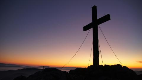 A cross stands against a beautiful dark blue background. Courtesy of Pexels.