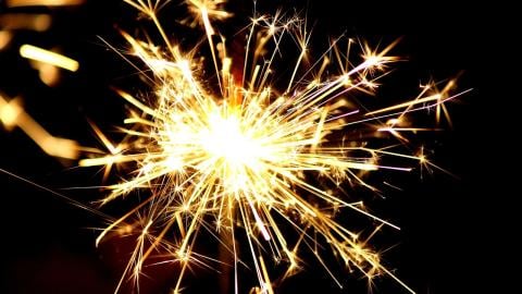 A firecracker sparkles on a black background