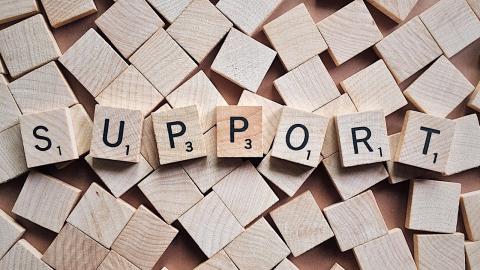 A group of scrabble letters spells the word "support"