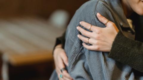 Woman embracing another person to comfort them