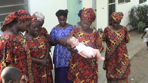A group of Nigerian women stand and bless a baby. Courtesy of Resonate Global Mission.